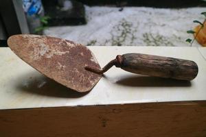 una pala oxidada con mango de madera foto