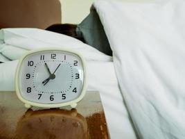 white alarm clock and sleeping woman photo