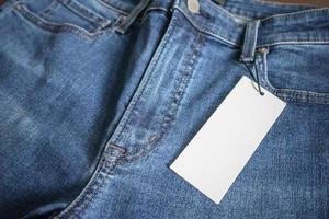 jeans azules con etiqueta de precio blanca en blanco foto