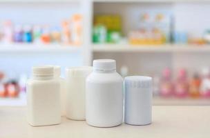 many medicine bottle with blur shelves of drug in the pharmacy drugstore background photo