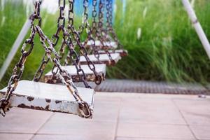 old wood swing in playground park photo