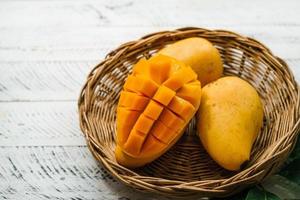 mango fruit,fresh yellow mango on white wood photo