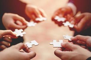 Close-up of a businessman with puzzle pieces in his hands arranged together. teamwork unity in teamwork The concept of combining physical strength and power at work. photo