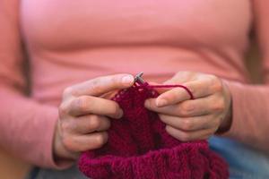 mujer está tejiendo, manos femeninas de cerca foto