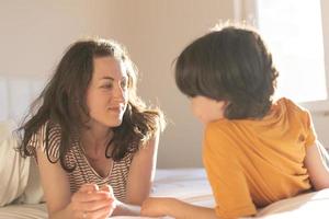 the boy with his mother lies on the bed photo