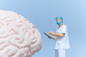Miniature People Surgeon analyzing patient brain