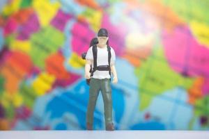 Miniature People Traveler with backpack on The Globe background photo