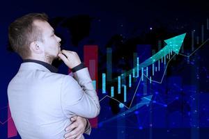Stock market growth graph, manipulations with forex against the background of a male businessman in a gray suit who is looking at a virtual screen with a graph. Double exposure. photo