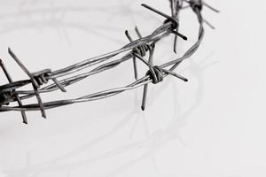 Barbed wire on a white background. Close-up, with sharp spikes arranged in a semicircle with reflection. copy space. photo