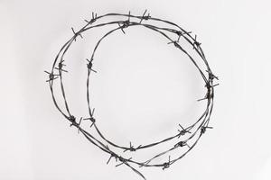 Barbed wire on a white background. Close-up, with sharp spikes arranged in a circle. copy space. photo