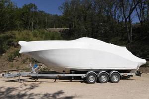 transporte de un nuevo barco de recreo, yate en un remolque de automóvil, semirremolque. foto