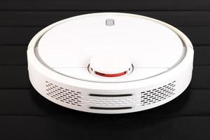 Modern white robotic, vacuum cleaner, isolated on black background. photo