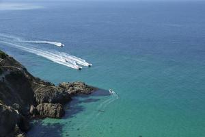 Pleasure boats approach the beautiful lagoon. View from the top of the cliff. Azure-emerald green sea water on a sunny day. photo