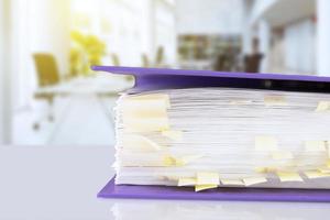 stack of reporting paper documents in a purple folder with bookmarks on the desktop in the office, business documents for annual reports. Business analytics. Business office concept, soft focus. photo