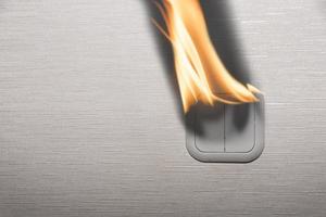 The electric switch on the inside wall of the house began to burn and smoke. Electric fires in residential buildings. copy space. photo