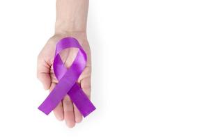 Purple satin ribbon on the palm of a woman, isolated on a white background. Cancer awareness symbol, epilepsy. copy space. photo