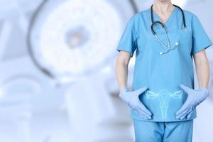 gynecologist in a medical uniform and a model of the reproductive system of a woman, the uterus, at the level of the pelvic bones of a woman, on a blurred background of a gynecological office. photo