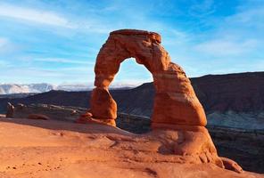 Classic postcard view of famous Delicate Arch, symbol of Utah and a popular scenic tourist attraction, in beautiful golden evening light at sunset in summer, Arches National Park, Moab, Utah, USA
