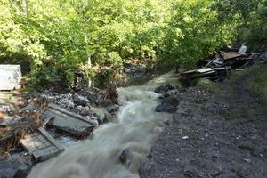 Dirty stream of a mountain river after rain and mudflow with soil erosion. Landslides and natural disasters concept photo