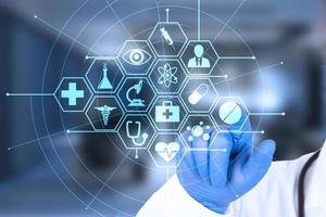 Doctor's hand points to the virtual screen, Medical innovation concept background. Health care icons on a blue background. photo