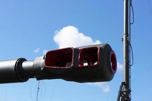 Muzzle barrel of military tank artillery gun on a blue sky background. copy space, selective focus, narrow depth of field. photo