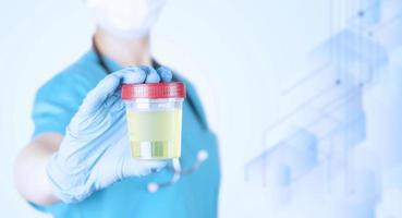 female doctor in a medical uniform, holds in her hands in gloves in front of her, a plastic container with a urine test. Medical Poster. Blue medical background from hexagons. copy space. photo