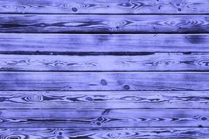 Wooden background. Aging boards by firing and brushing. A beautiful universal natural background made of textured boards in trendy purple color Very Peri. copy space. photo