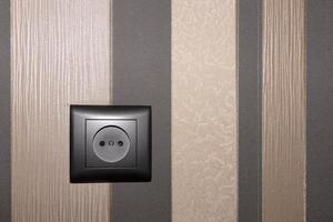 Brown electric socket on an interior wall in brown tones. copy space. photo