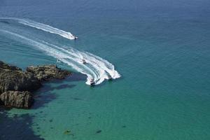 Pleasure boats approach the beautiful lagoon. View from the top of the cliff. Azure-emerald green sea water on a sunny day. photo