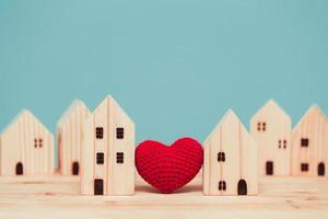corazón de amor entre dos modelos de madera de la casa para quedarse en casa para un concepto de comunidad saludable juntos. foto