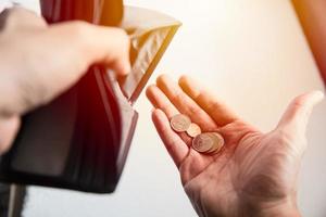 la gente se enfrenta a una recesión económica. no hay dinero en la billetera, solo quedan monedas como un pobre hombre arruinado. foto