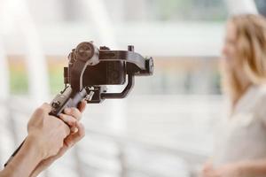 motorized gimbal, videographer using dslr camera anti shake tool for stabilizer record video scene. photo