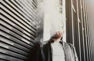 man smokes an electronic cigarette photo