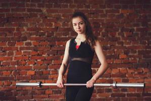 Young girl stands with a barbell photo