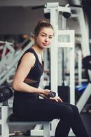 girl picks up dumbbells in the gym photo