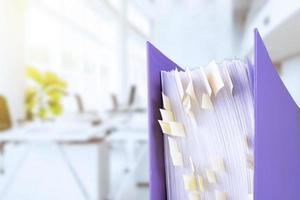 stack of reporting paper documents in a purple folder with bookmarks on the desktop in the office, business documents for annual reports. Business analytics. Business office concept, soft focus. photo