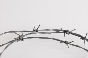 Barbed wire on a white background. Close-up, with sharp spikes arranged in a circle. copy space. photo