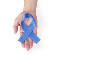 Blue satin ribbon on a woman's palm, isolated on a white background. Cancer awareness symbol, men's health. copy space. photo