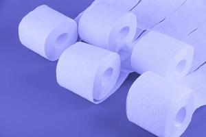 Toilet paper rolls in trendy purple color Very Peri laid out in a pattern. Toned background. photo