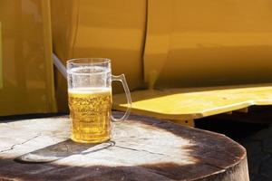 vaso medio lleno de cerveza en la calle. foto