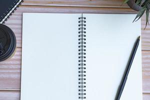 Directly above view of notepad and pen on wooden desk. Flat lay. photo