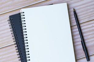 Directly above view of notepad and pen on wooden desk. Flat lay. photo