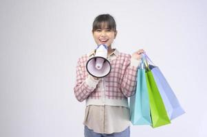 Shopper atractiva mujer sosteniendo bolsas de compras sobre fondo blanco. foto