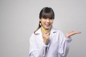 Una joven dentista sonriendo sobre un estudio de fondo blanco foto