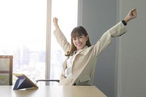 Beautiful business woman  relaxing and stretching in modern office photo