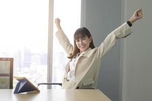 hermosa mujer de negocios relajándose y estirándose en la oficina moderna foto