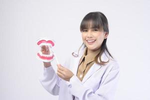 Una joven dentista sonriendo sobre un estudio de fondo blanco foto