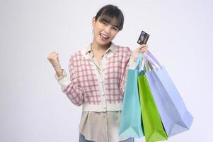 Shopper atractiva mujer sosteniendo bolsas de compras sobre fondo blanco. foto