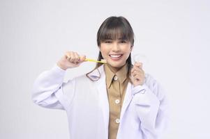 Una joven dentista sonriendo sobre un estudio de fondo blanco foto