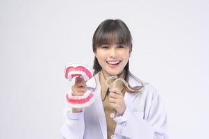 Young female dentist smiling over white background studio photo